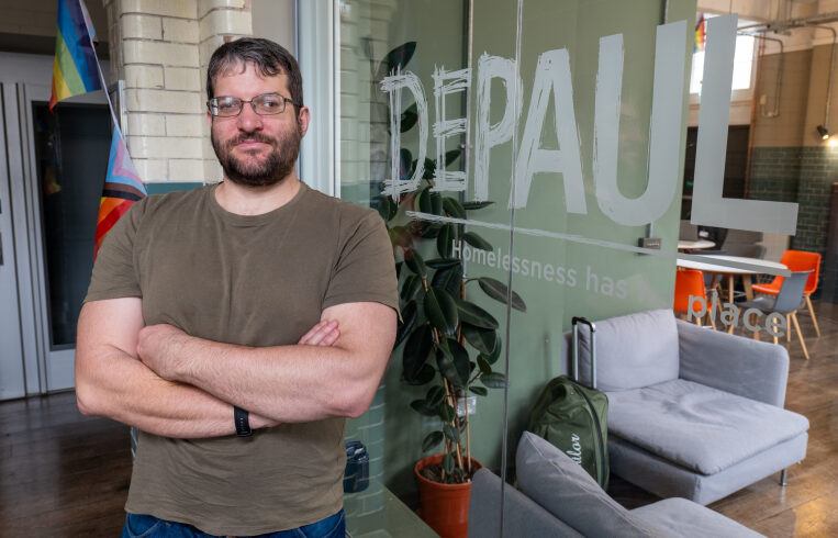 Alex Szoard standing in the Depaul UK offices.